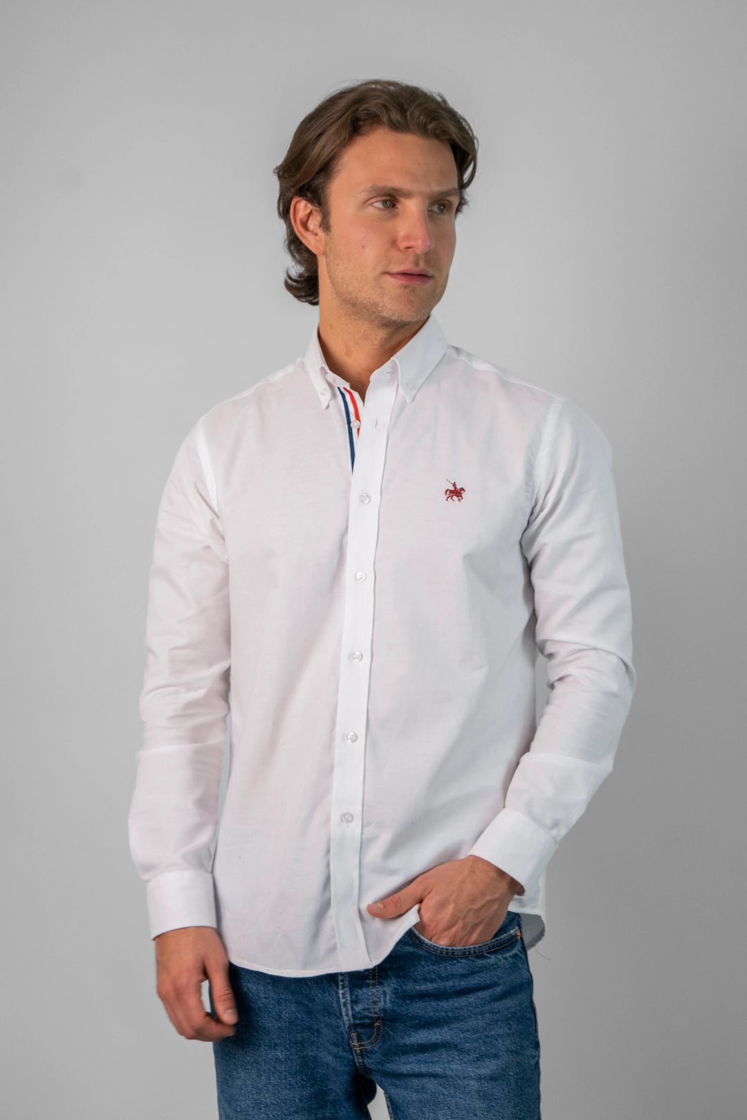 Modelo masculino vistiendo la camisa blanca France. La camisa se combina con jeans para un look casual.