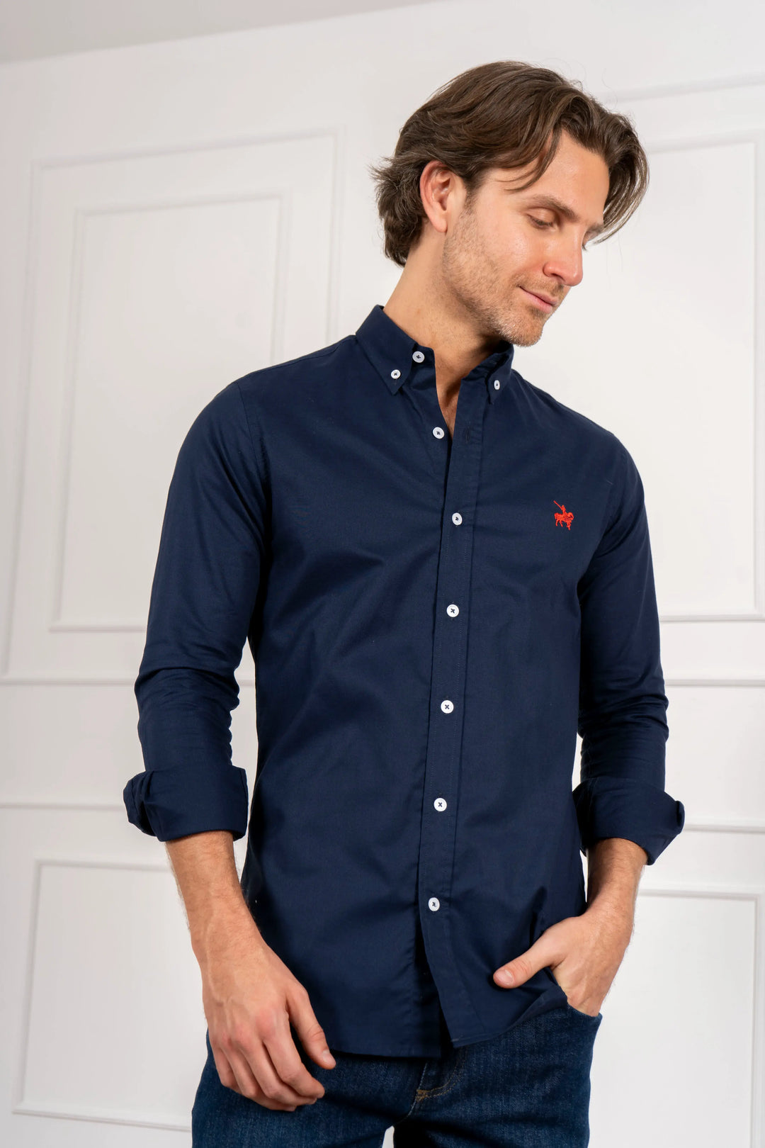 Camisa hombre azul oscuro tipo oxford, logo bordado rojo. Material 100% algodón