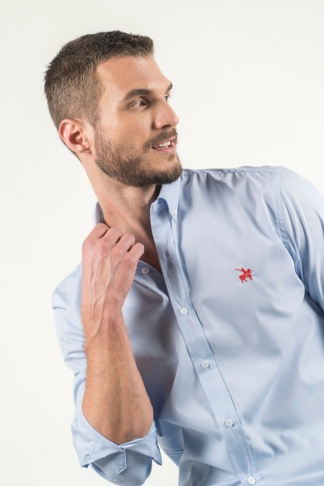 Camisa azul claro con logo bordado rojo. Confeccionada con tela de tejido suave y liso para asegurar la máxima comodidad.