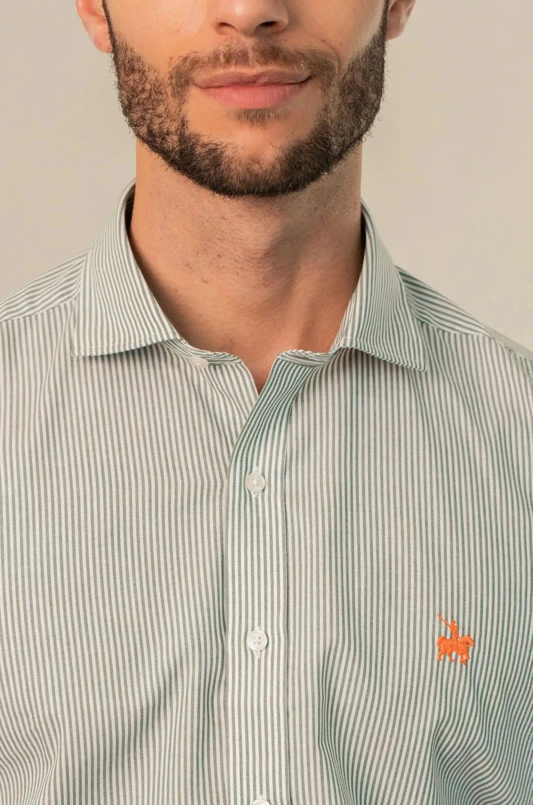Camisa para hombre manga larga de rayas finas verdes claro y base blanca. Logo naranja. complemento perfecto para un look casual e informal.
